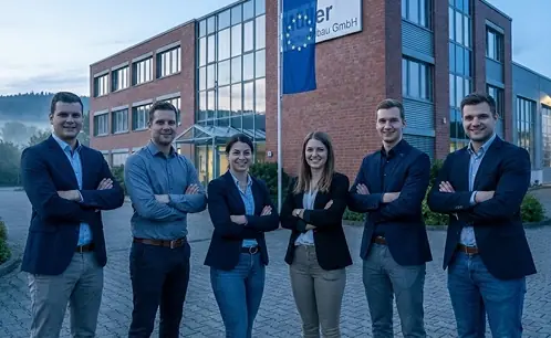 Gruppe junger Fachkräfte vor einem Firmengebäude